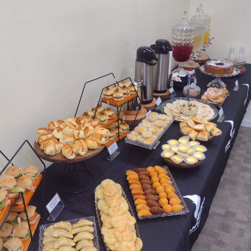 Mesa de buffet com lanches, salgadinhos e aperitivos de coffee break