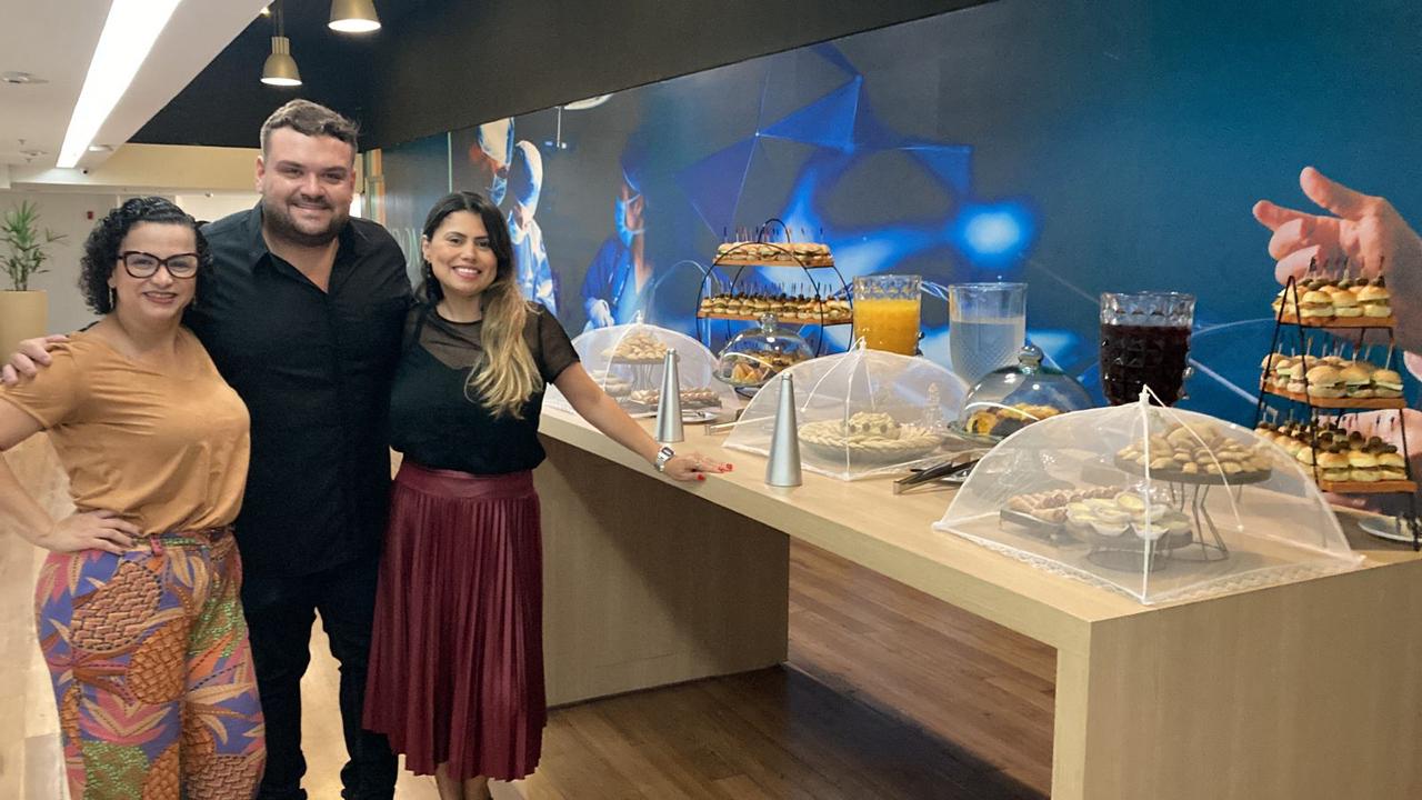 Mesa de buffet com lanches e pessoas ao lado